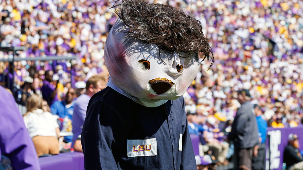 LSU’s Mike the Tiger stalks referee while dressed as Michael Myers, appears to be steered away by staffer